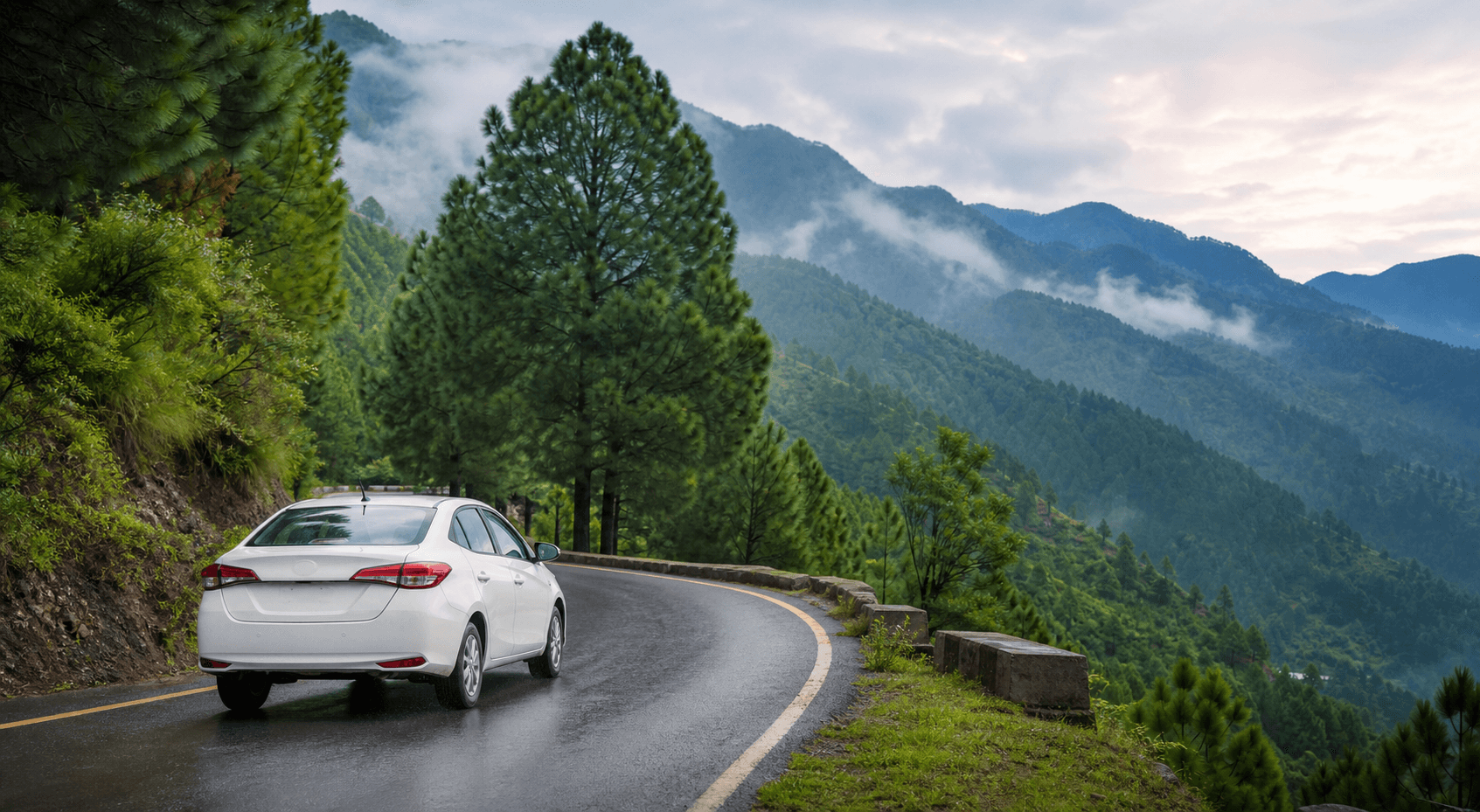 White private taxi driving on a wet mountain road through pine forests on the way from Islamabad to Nathia Gali
